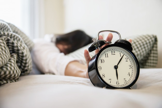 sleepy-woman-reaching-holding-alarm-clock_1150-6975.jpg