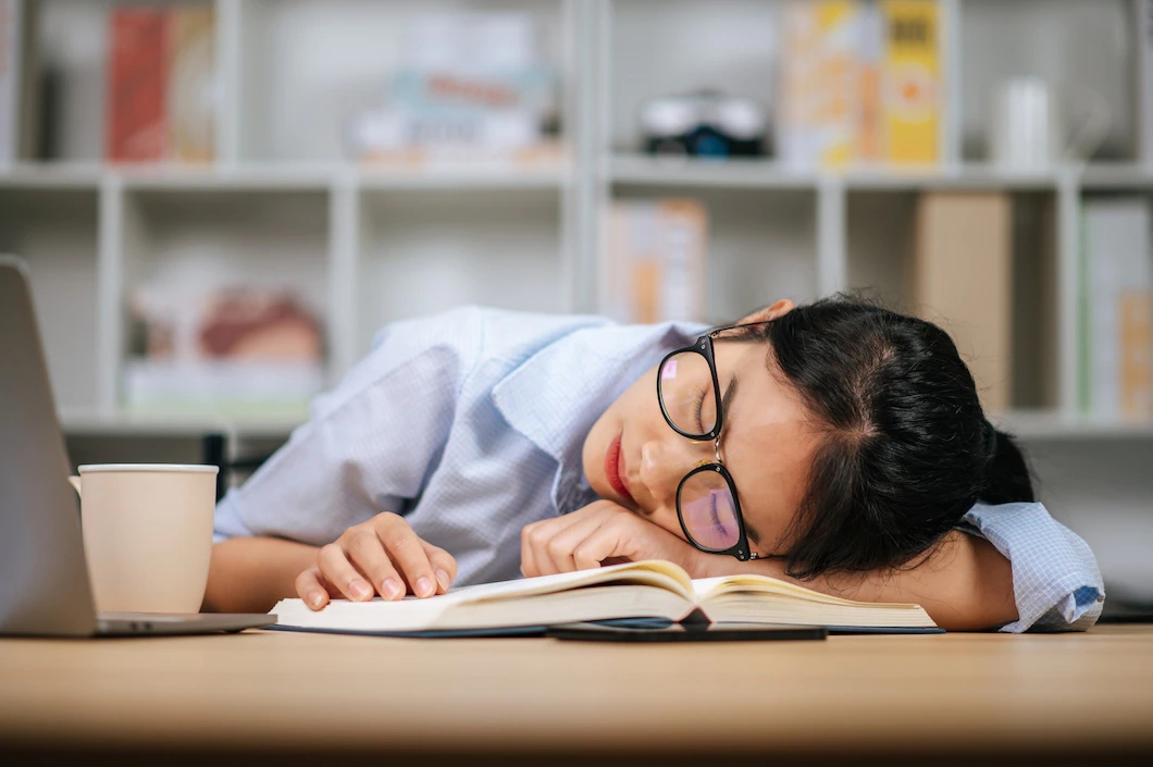 young-asian-tired-woman-eyeglasses-sleeping-desk-with-laptop-textbook-home_1150-48601.webp.jpg