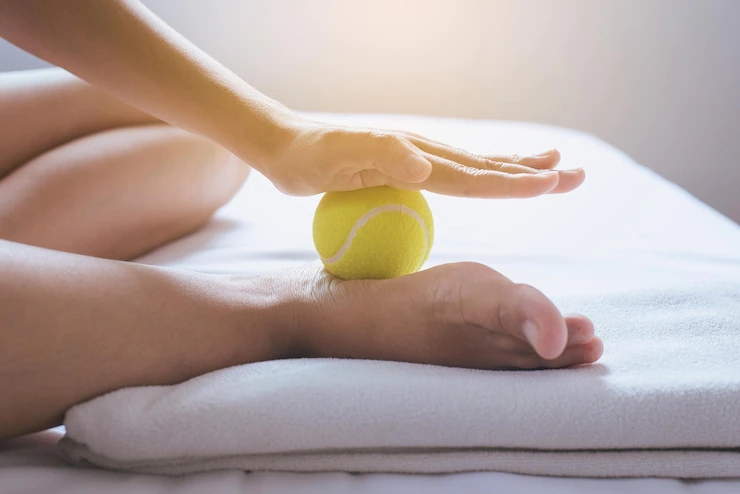 foot-soles-massagewoman-hands-giving-massage-with-tennis-ball-foots-bedroom_179202-618.webp.jpg